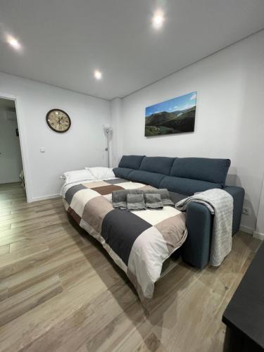 sypialnia z dużym łóżkiem i zegarem na ścianie w obiekcie Casa da Margarida w mieście Vila Nova de Foz Côa