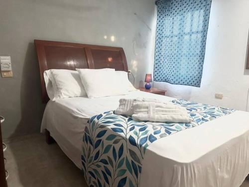 a bedroom with a bed with a blue window at Isla Mujeres departamento, hasta para 6 personas. in Isla Mujeres
