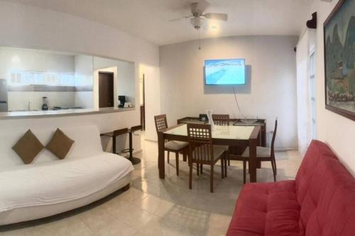 a living room with a white couch and a table at Isla Mujeres departamento, hasta para 6 personas. in Isla Mujeres