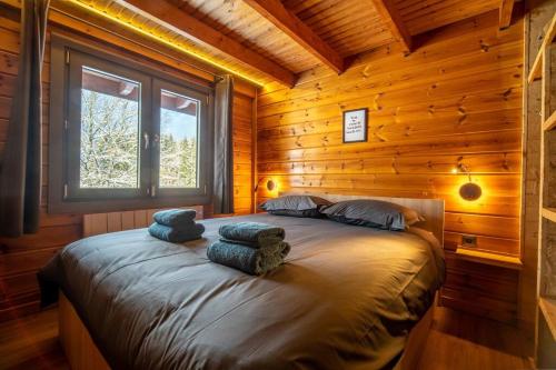 a bedroom with a bed in a log cabin at Pétillant Chalet aux 3 étangs avec SPA, Sauna et Véranda in Gerbépal