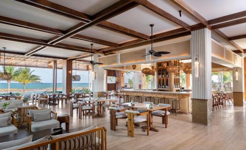 a restaurant with tables and chairs and a bar at Fairmont Mayakoba in Playa del Carmen
