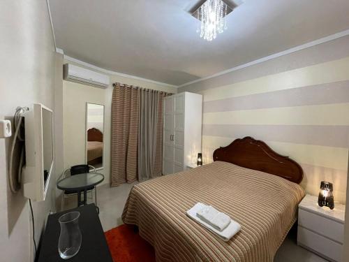 a bedroom with a bed and a table and a mirror at Cantinho da Lena in Sacavém