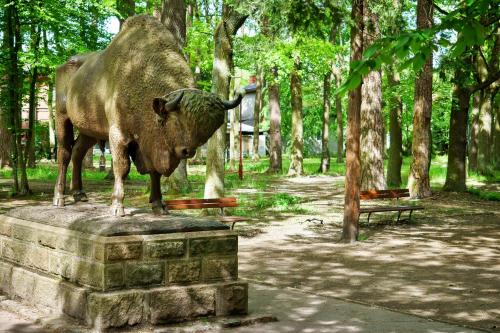 a statue of a bull standing on a stone block at Spalskie Pokoje Gościnne in Spała