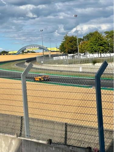 einen Zaun vor einer Rennstrecke in der Unterkunft Chambre à 25 min du circuit des 24h . in La Bazoge