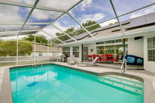 a swimming pool with a pergola on a house at Lanai and Grill Sunny Home Near Rainbow Springs! in Dunnellon