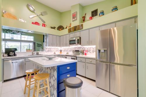 a kitchen with white cabinets and a refrigerator at Lanai and Grill Sunny Home Near Rainbow Springs! in Dunnellon
