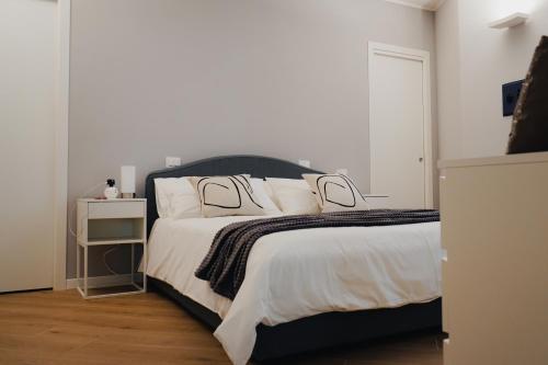 1 dormitorio con 1 cama grande con sábanas y almohadas blancas en Exclusive Apartment in Piazza Italia in Perugia, en Perugia