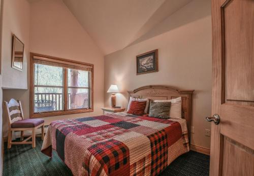 Schlafzimmer mit einem Bett und einem Fenster in der Unterkunft Hidden River Lodge 5995 in Keystone