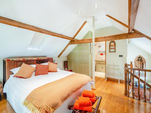 a bedroom with a large bed with orange pillows at The Old Parish Hall in Quendon