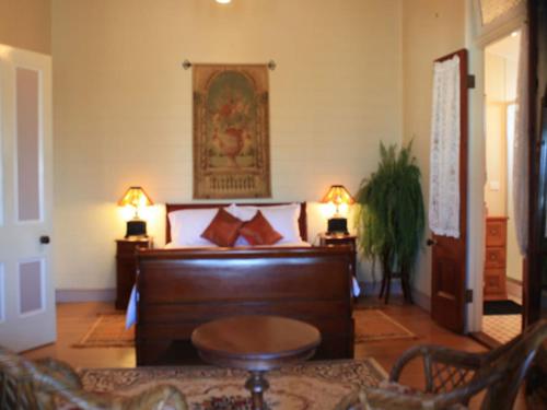 1 dormitorio con 1 cama con 2 lámparas y 1 mesa en Classique Bed & Breakfast, en Townsville