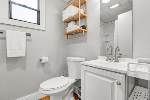 a white bathroom with a toilet and a sink at Abellona Inn & Suites in Old Orchard Beach