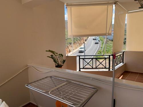 a balcony with a window with a view of a highway at Christi Apartments Α&Β in Kokkíni Khánion