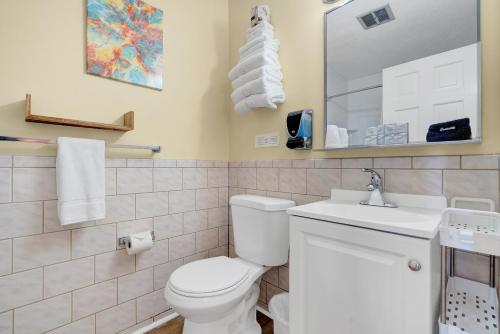 a bathroom with a toilet and a sink and a mirror at Abellona Inn & Suites in Old Orchard Beach