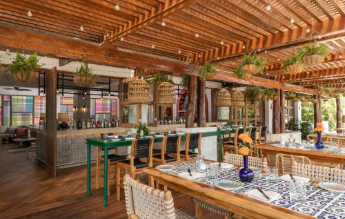 a restaurant with wooden ceilings and tables and chairs at Fairmont Mayakoba in Playa del Carmen