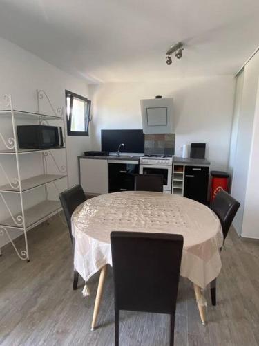 une cuisine avec une table et des chaises dans une pièce dans l'établissement U Primu Appartement spacieux au calme Aléria, à Aléria