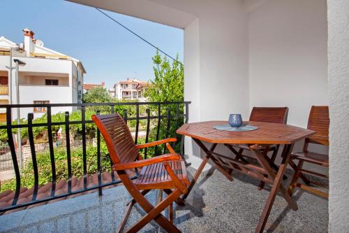 a balcony with a wooden table and two chairs at Apartments Vanda Rovinj in Rovinj