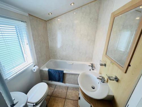 a bathroom with a tub and a sink and a toilet at 2 Bedroom Lodge TH35, Nodes Point, St Helens, Isle of Wight in Saint Helens