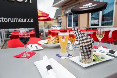 a table with glasses of wine and a plate of food at Hotel V in Gatineau