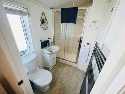 y baño con aseo, ducha y lavamanos. en 2 Bedroom Lodge TH35, Nodes Point, St Helens, Isle of Wight, en Saint Helens