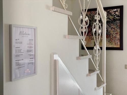 a white staircase with a sign on the wall at Horizon Villa Mani - Seaview Family Friendly House in Stoupa