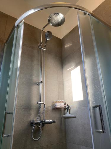 y baño con ducha y puerta de cristal. en Horizon Villa Mani - Seaview Family Friendly House, en Stoupa