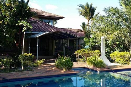 una casa con piscina frente a una casa en Andalucia, en Villavicencio