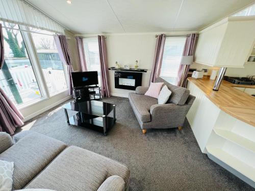a living room with two couches and a tv at 2 Bedroom Lodge TH35, Nodes Point, St Helens, Isle of Wight in Saint Helens