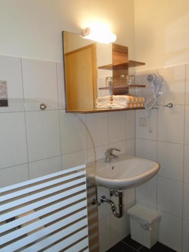 a white bathroom with a sink and a shower at Pension Jahnkes Gasthaus in Todesfelde
