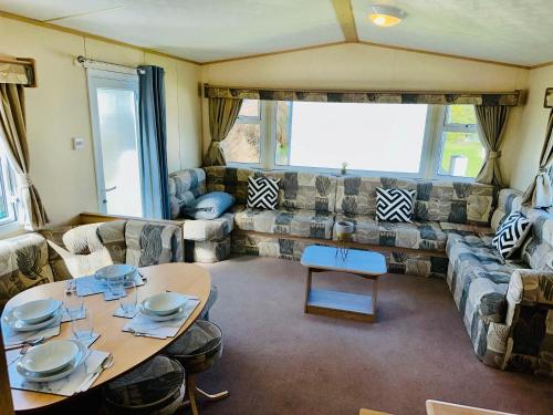 ein Wohnzimmer mit einem Tisch und einem Sofa in der Unterkunft My Leisure Home On Fantasy Island in Ingoldmells