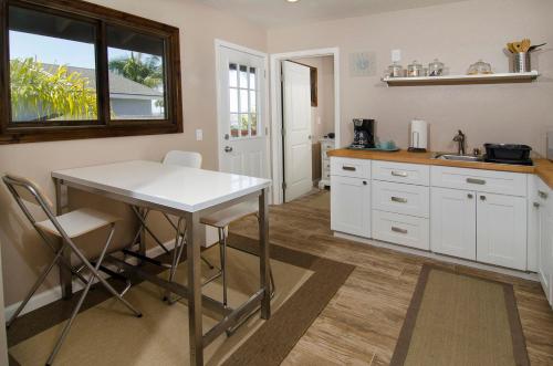 卡爾斯巴德的住宿－Casa La Costa Casita-30 days minimum，厨房配有白色橱柜、桌子和窗户。