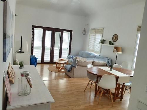 Una cocina y una sala de estar con mesa y sillas. en Villa Casa Frontera -private pool-, en Costa Teguise