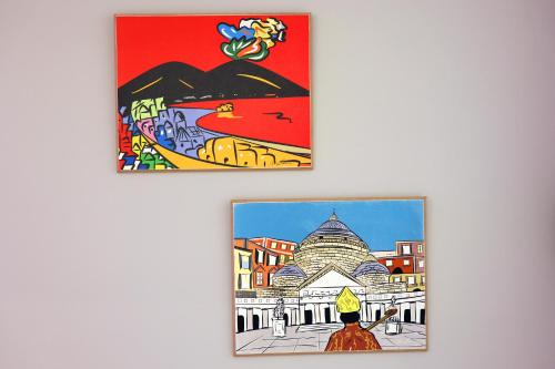 deux affiches encadrées d'une ville et d'un bâtiment dans l'établissement Napolitan Pop House, à Naples