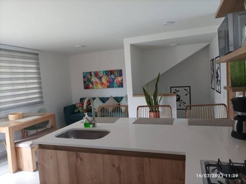 a kitchen with a sink and a living room at Apto Nuevo, Tranquilo,Bonito,5 min Plaza Principal in Guatapé