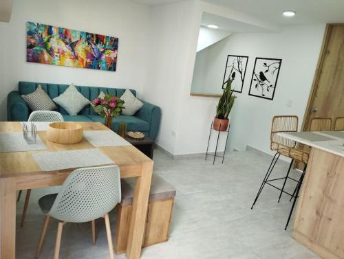 a living room with a blue couch and a table at Apto Nuevo, Tranquilo,Bonito,5 min Plaza Principal in Guatapé