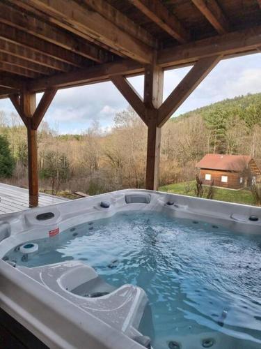 un bain à remous assis sous un toit dans l'établissement L'orée des bois, SPA et Sauna, à Gerbépal