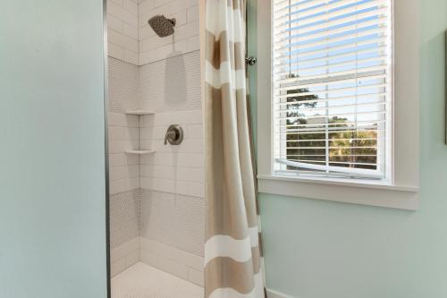 a bathroom with a shower with a shower curtain at Bungalows at Seagrove 135 - MerSea in Seagrove Beach