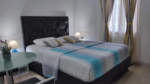 a bedroom with a large bed and a table at BELLA SUITE frente al Aeropuerto in Catia La Mar
