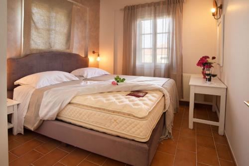a bedroom with a large bed and a window at Magnolia Apartments in Fiskardho