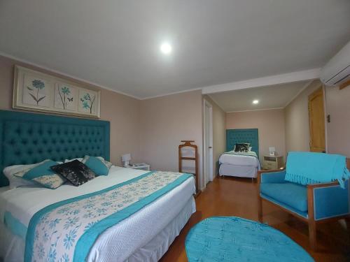 una habitación de hotel con 2 camas y una silla en Hotel Rarinco en Los Ángeles