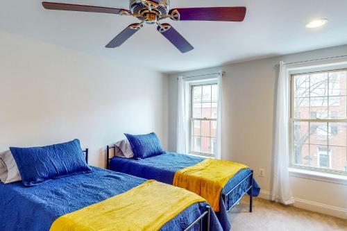 a bedroom with two beds and a ceiling fan at The Trailblazing Tribble House of Federal Hill in Baltimore