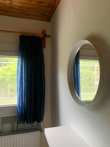 a bathroom with a mirror and a blue curtain at Nadia's Beach House in Pefkari