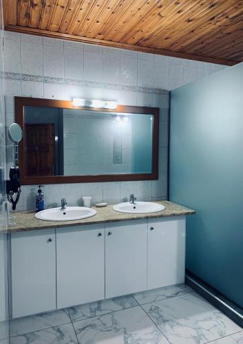 a bathroom with two sinks and a mirror at Nadia's Beach House in Pefkari
