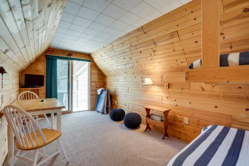um quarto com uma parede de madeira, uma cama e uma secretária. em Lake Pepin Waterfront Cottage - Steps to Beach! em Lake City