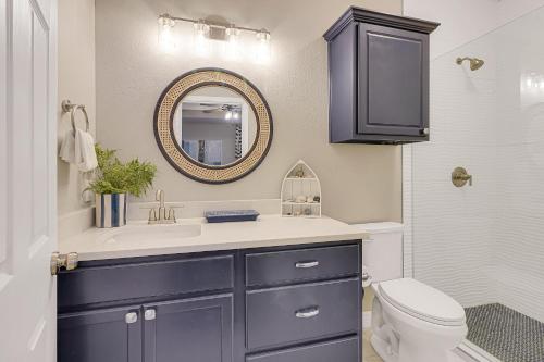 a bathroom with a sink and a toilet and a mirror at Palm Tree Paradise in Padre Island