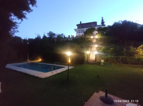 a swimming pool in a yard with a house in the background at Los Cipreses in Córdoba