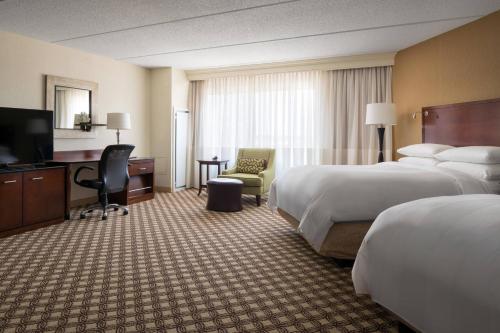 a hotel room with two beds and a flat screen tv at Chicago Marriott Naperville in Naperville