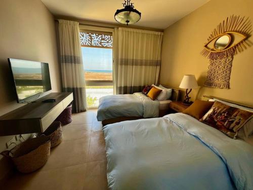 洪加達的住宿－Mangroovy Seafront condo - Great Kite Surfing，酒店客房设有两张床和窗户。