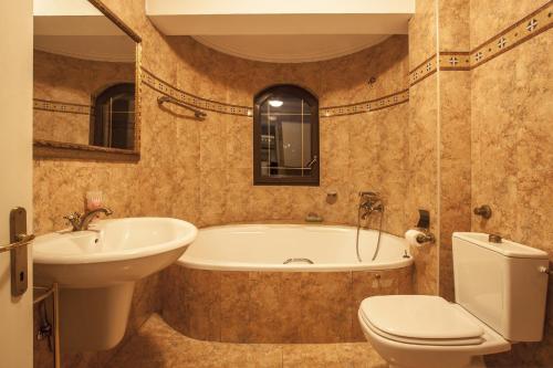 ein Badezimmer mit einer Badewanne, einem WC und einem Waschbecken in der Unterkunft Central Exclusive Apartment/Penthouse in Bitola