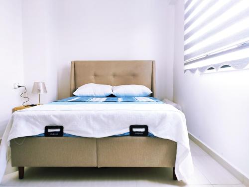 ein weißes Schlafzimmer mit einem Bett mit weißer Bettwäsche und einem Fenster in der Unterkunft Denizolgun Homes Tenim Suit Apart 3 in Dalaman