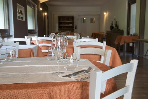 a table with white chairs and wine glasses on it at Cascina il Faggio Country House in Mosso Santa Maria